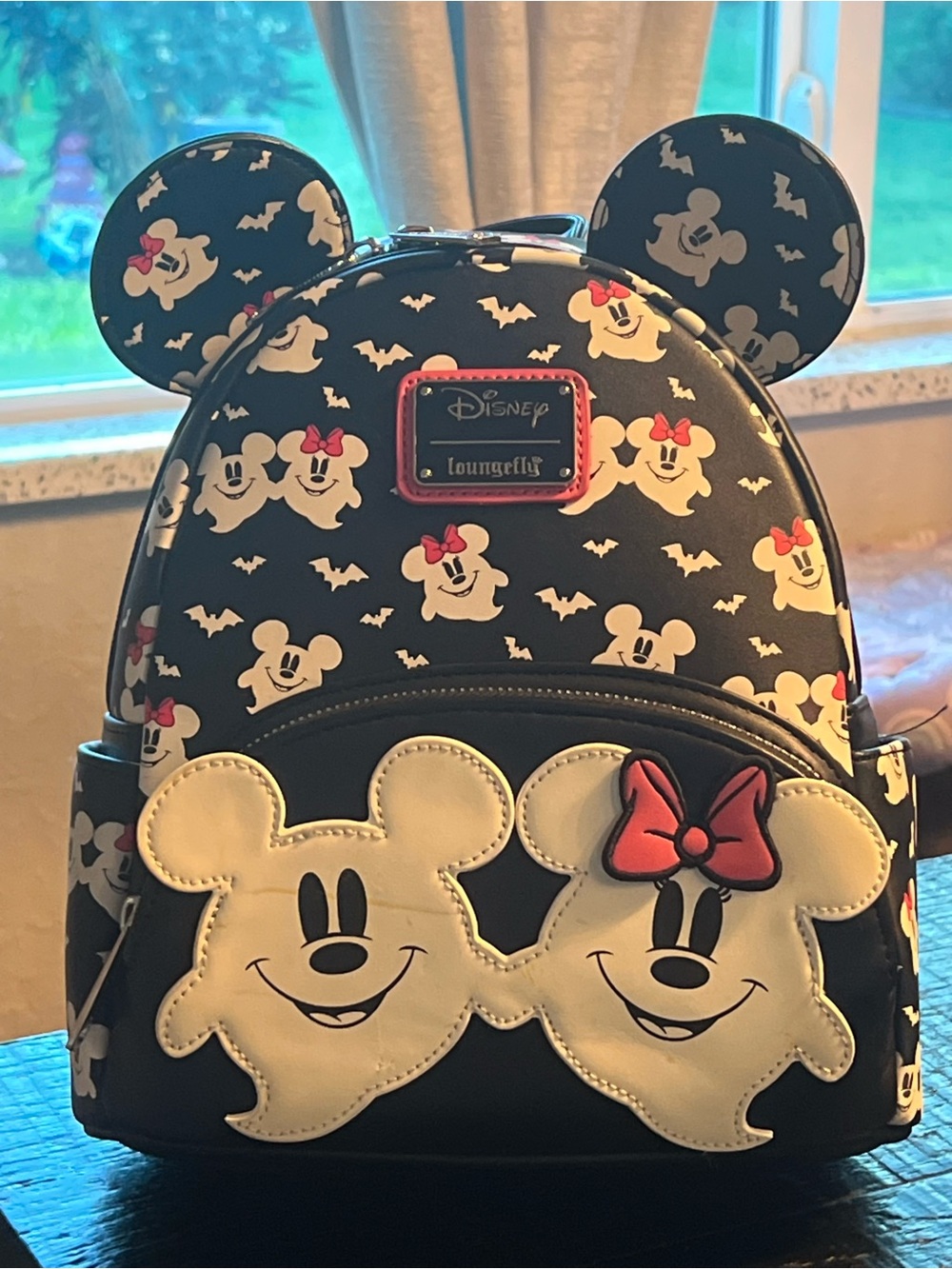 Loungefly Black Minnie & Mickey Ghost Ears Mini Backpack with pink bow accent.